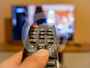 TV controller pointing to the switched on TV