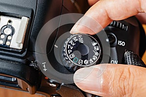 Tv dial mode on dslr camera with fingers on the dial