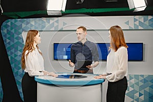 Tv host and two participants on game show photo