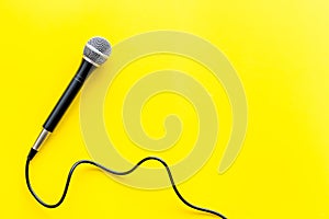 TV news concept. Microphone on yellow background top-down copy space