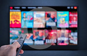 Tv online. Television streaming video. Male hand holding TV remote control. Multimedia streaming concept. VoD content provider.