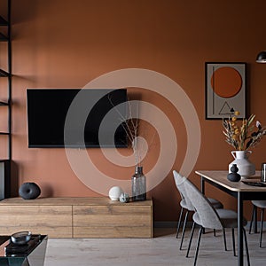 Tv on orange wall in dining room