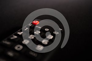 TV power button on the remote control on black background