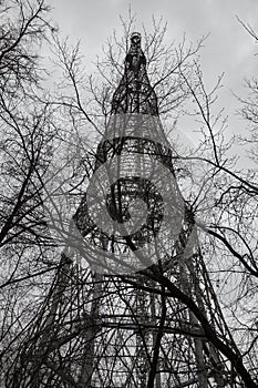 TV and radio tower and tree branches on the sky background