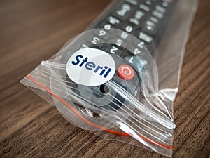 TV remote control in steril bag ready to use in hotel room. Coronavirus concept photo