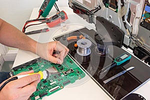 TV repair in the service center, engineer soldering electronic components