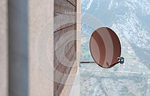 TV sattelite dish mounted on a wooden house wall