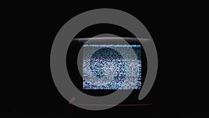 TV screen on at night with a white noise. Stock. Static noise on the old TV screen in the dark