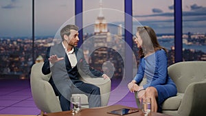 Tv show presenter interviewing man guest in modern television channel studio