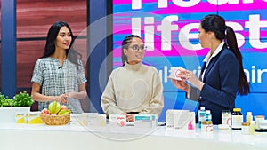 TV Talk Show Infomercial: Diverse Female Professionals Present Mock-up Beauty Products Boxes. Host