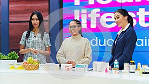 TV Talk Show Infomercial: Diverse Female Professionals Present Mock-up Beauty Products Boxes. Host