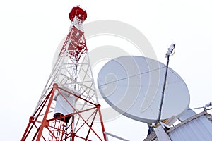 TV tower and satellite dish against the white sky