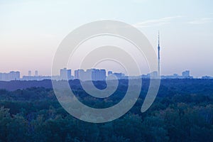 TV tower and urban houses in early blue dawn