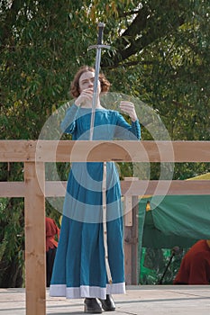 A girl in a long dress demonstrates her sword skills