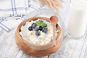 Tvorog or cottage cheese in wooden bowl