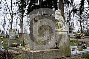 TVRDOMESTICE, SLOVAKIA - 12.3. 2016: Graves, tombstones and crucifixes on traditional cemetery. Statue of an angel on old tomb