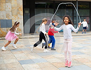 Tween African American girl skipping rope in schoolyard