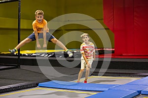 Tween boy jumping on trampoline on indoor inflatable playground