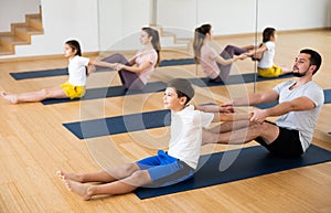 Tween boy practicing partner yoga in pair with father