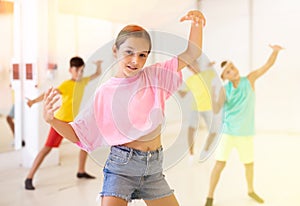 Tween girl breakdancer posing during group dance class