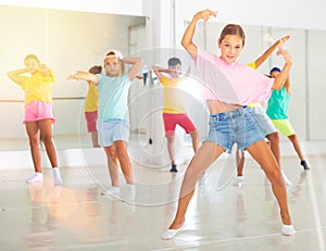 Tween girl breakdancer posing during group dance class