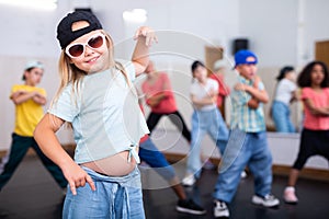 Tween girl hip hop dancer posing during group workout