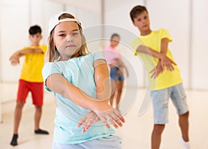 Tween girl krump dancer in choreographic studio with children