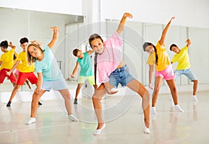 Tween girl krump dancer in choreographic studio with children