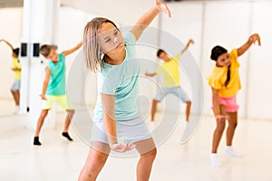 Tween girl krump dancer in choreographic studio with children