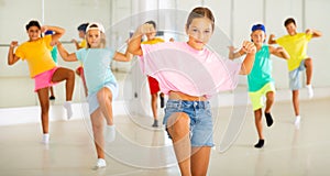 Tween girl krump dancer in choreographic studio with children