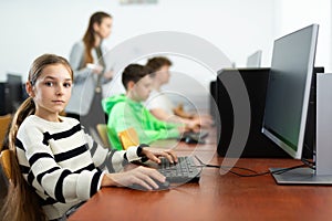 Tween girl during lesson in computer room of school library