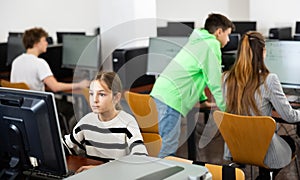 Tween girl during lesson in computer room of school library