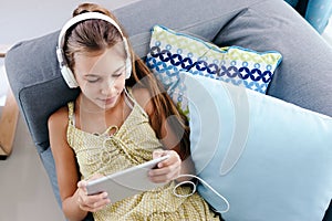 Tween girl relaxing on couch at home