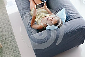 Tween girl relaxing on couch at home