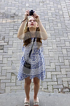 Tween girl standing looking up with camera