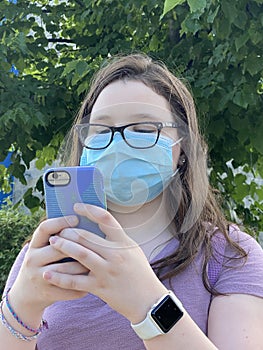 Tween Girl Wearing Surgical Mask Outdoors Texting On her Mobile Phone