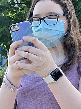 Tween Girl Wearing Surgical Mask Texting Outdoors