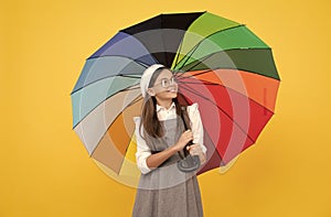 tween with vivid rain protection. happy school girl in glasses. teen child under colorful parasol