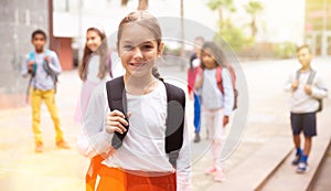 Tweenager girl with backpack walking after lessons