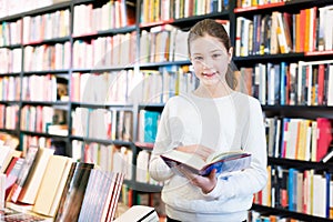 tweenager girl reading interesting book in bookstore