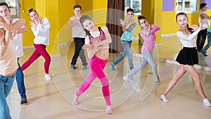 Tweens exercising with coach in choreography class photo