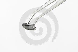 Tweezers Holding Microchip On White