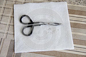 Tweezers and nose hair on a white napkin