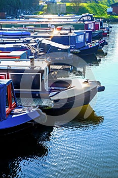 Twelve long traditional british canal boats moored directly next