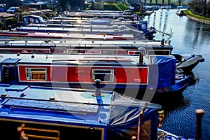 Twelve long traditional british canal boats moored directly next