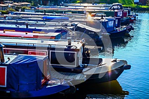 Twelve long traditional british canal boats moored directly next