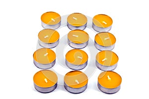 Twelve scented candles lie on a white background. Candles have a mango flavor