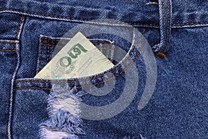 Twenty baht banknote of Thailand in the pocket of blue jeans.