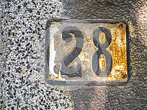 Twenty eight street number of an old house. 28