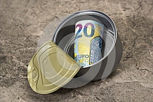 Twenty euro in a tin can falling on the stone background
